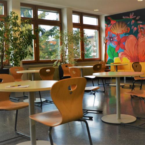 Aufenhtaltsraum, gelbe Couch, Wandbild Blumen