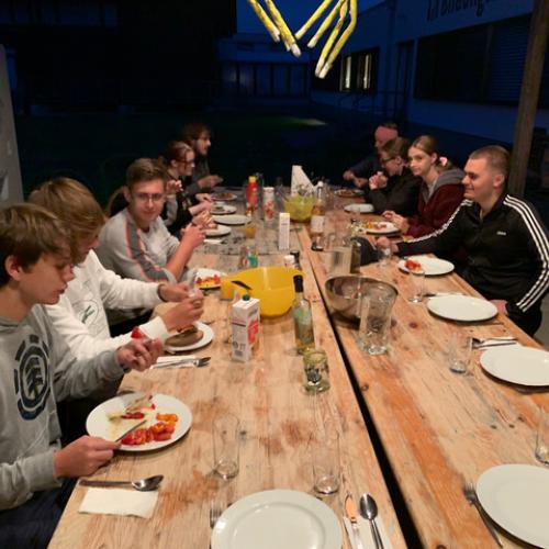 SuS beim gemeinsamen Abendessen an einem langen Tisch sitzend