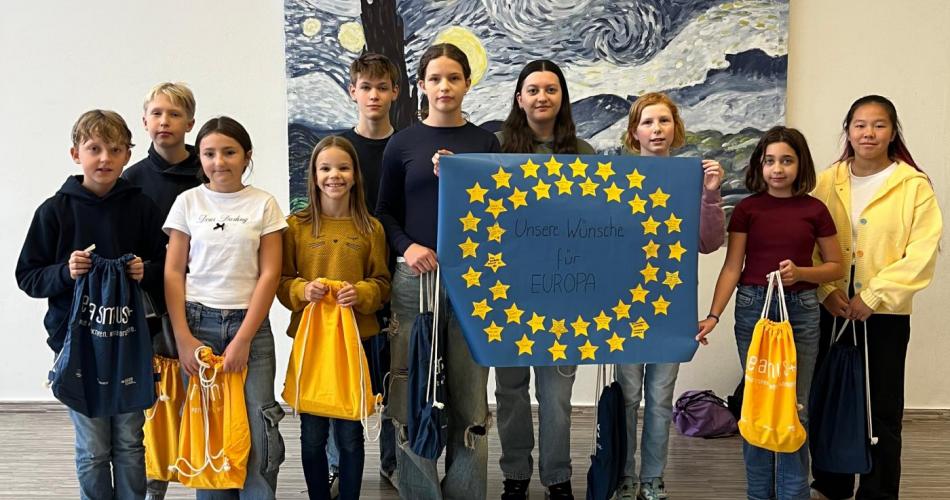 Schüler:innen präsentieren stolz Europaflagge